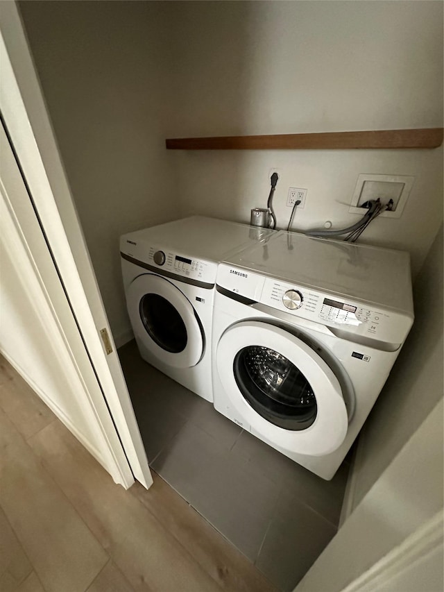 563 Long Beach Rd, Island Park, NY 11558 - laundry area with washing machine and clothes dryer and dark tile patterned flooring