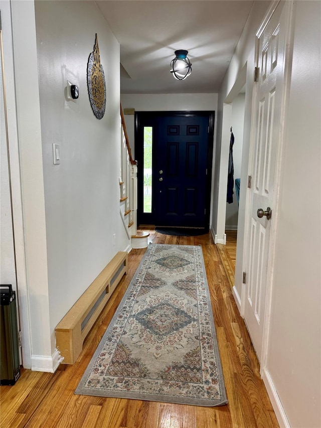 2337 Sycamore Ave, Ronkonkoma, NY 11779 - foyer entrance with wood finished floors, baseboards, stairs, and a baseboard radiator