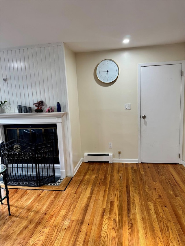 2337 Sycamore Ave, Ronkonkoma, NY 11779 - detailed view of a baseboard radiator, wood finished floors, a fireplace, and baseboards