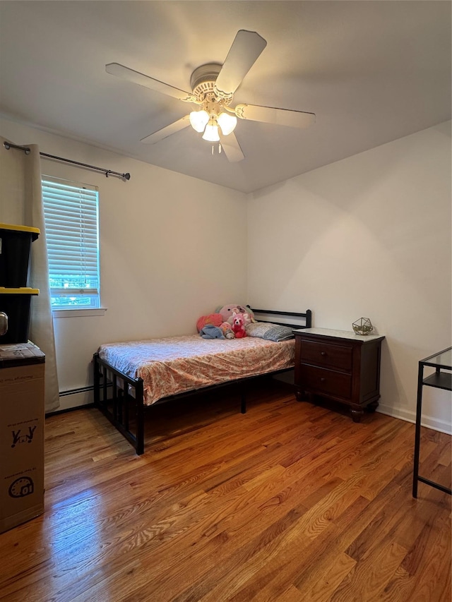 2337 Sycamore Ave, Ronkonkoma, NY 11779 - bedroom with wood finished floors, a ceiling fan, and a baseboard heating unit