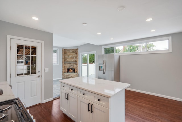 3061 Xavier Ct, Oceanside, NY 11572 - kitchen with stainless steel fridge, dark wood-style flooring, a stone fireplace, plenty of natural light, and recessed lighting