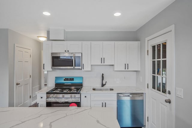 3061 Xavier Ct, Oceanside, NY 11572 - kitchen featuring stainless steel appliances, a sink, white cabinets, light stone counters, and recessed lighting