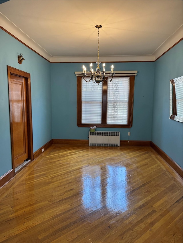 6472 84th St, Middle Village, NY 11379 - spare room with radiator heating unit, a chandelier, crown molding, and wood finished floors