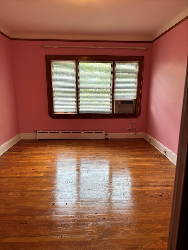 6472 84th St, Middle Village, NY 11379 - unfurnished room with a baseboard heating unit, cooling unit, crown molding, and wood finished floors