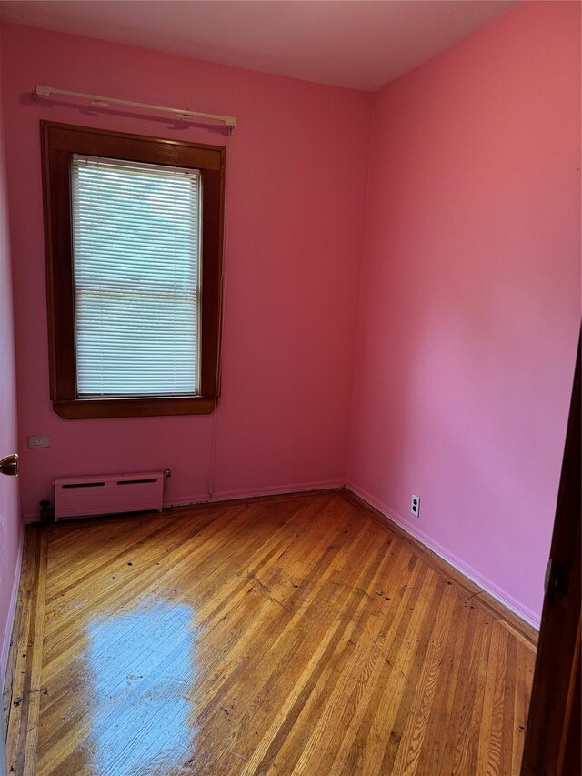 6472 84th St, Middle Village, NY 11379 - empty room with baseboard heating and light wood-style floors