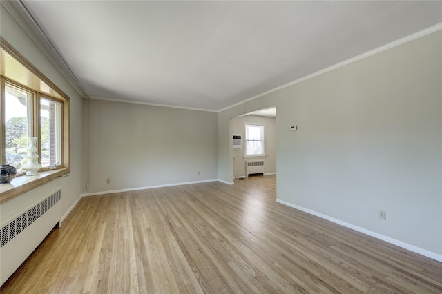 8123 260th St, Glen Oaks, NY 11004 - empty room featuring radiator, light wood-style floors, baseboards, and crown molding
