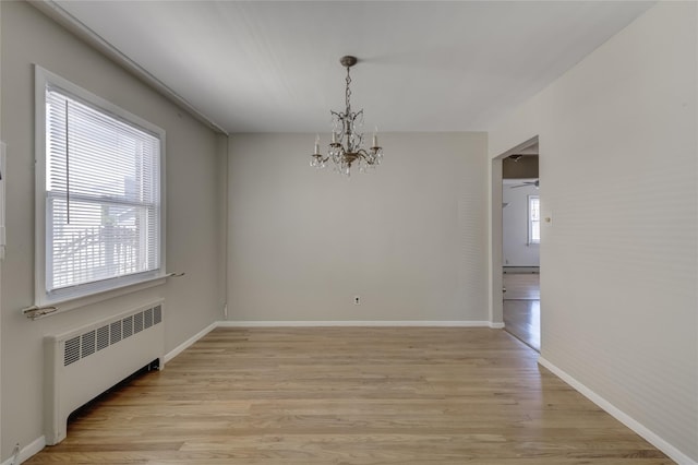 8123 260th St, Glen Oaks, NY 11004 - spare room with radiator, a chandelier, light wood-type flooring, and baseboards