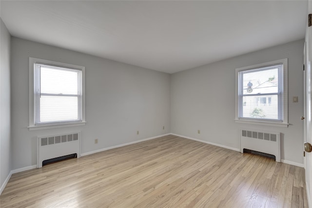 8123 260th St, Glen Oaks, NY 11004 - empty room with radiator heating unit, light wood-type flooring, and baseboards