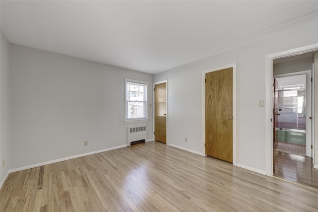 8123 260th St, Glen Oaks, NY 11004 - unfurnished bedroom featuring radiator, light wood-type flooring, and baseboards