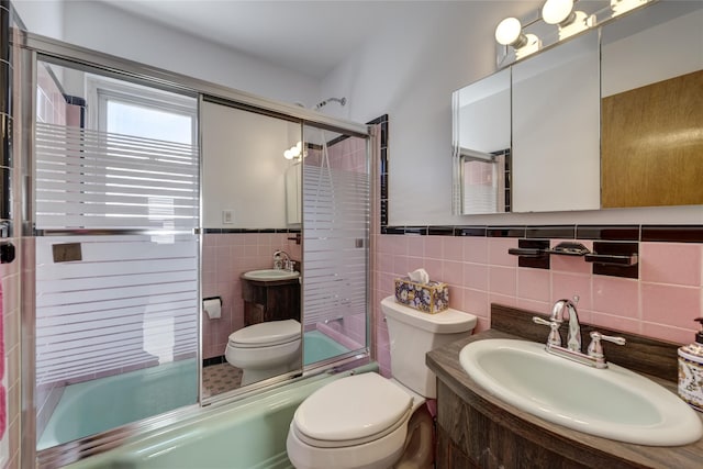 8123 260th St, Glen Oaks, NY 11004 - full bathroom with toilet, tile walls, shower / bath combination with glass door, vanity, and a wainscoted wall