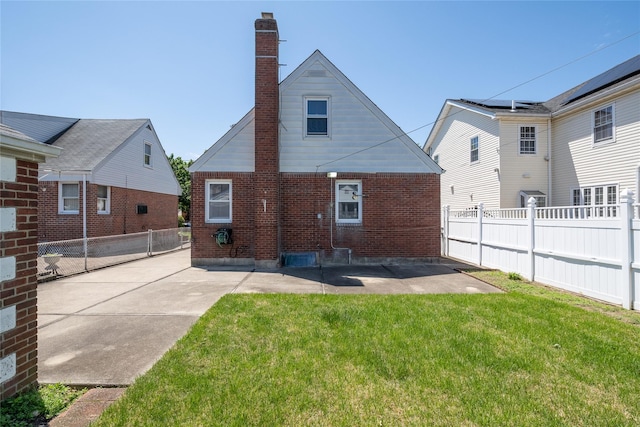 8123 260th St, Glen Oaks, NY 11004 - back of house featuring a chimney, brick siding, and a patio