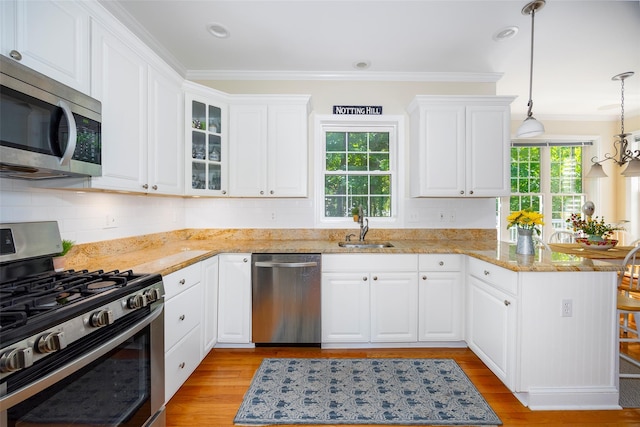 3 Cambridge Ct, Wappingers Falls, NY 12590 - kitchen featuring stainless steel appliances, a peninsula, a sink, light wood finished floors, and ornamental molding
