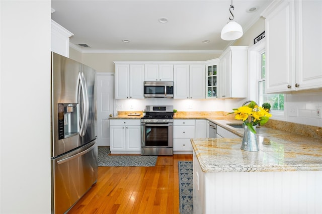 3 Cambridge Ct, Wappingers Falls, NY 12590 - kitchen featuring stainless steel appliances, white cabinetry, light wood finished floors, ornamental molding, and hanging light fixtures
