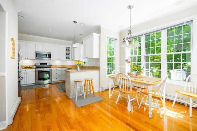 3 Cambridge Ct, Wappingers Falls, NY 12590 - kitchen featuring appliances with stainless steel finishes, ornamental molding, a peninsula, light wood-style floors, and white cabinets