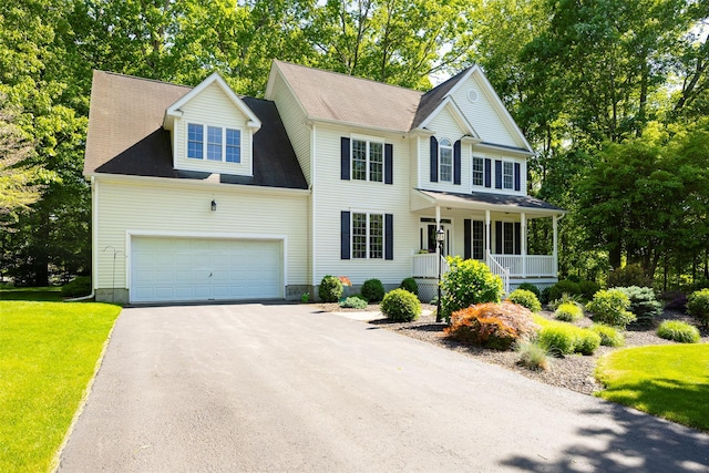 3 Cambridge Ct, Wappingers Falls, NY 12590 - colonial-style house with a porch, asphalt driveway, a front lawn, an attached garage, and view of scattered trees