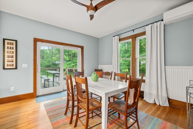 858 N Branch Hortonville Rd, North Branch, NY 12745 - dining space with a wall mounted air conditioner, ceiling fan, a wainscoted wall, and light wood-style floors