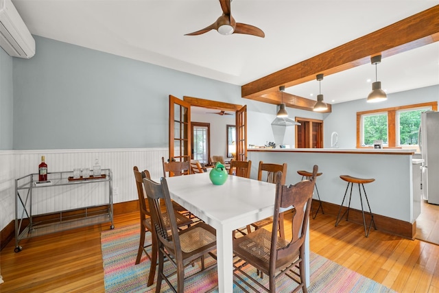 858 N Branch Hortonville Rd, North Branch, NY 12745 - dining space with ceiling fan, wood finished floors, a wall mounted AC, a wainscoted wall, and beamed ceiling