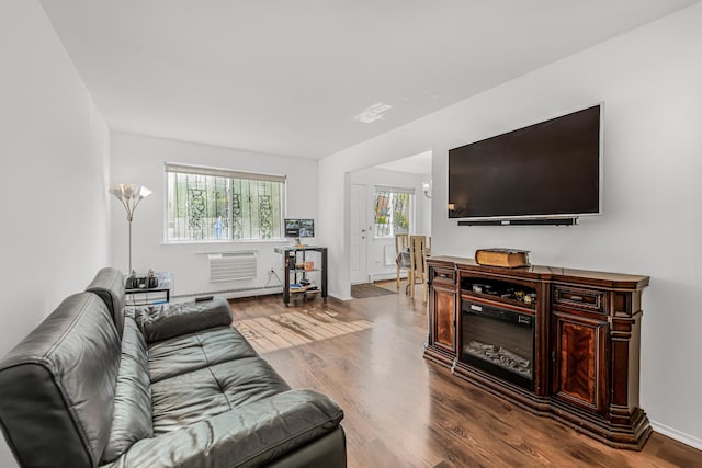 3665 Varian Ave, Bronx, NY 10466 - living area featuring dark wood-style floors, an AC wall unit, a baseboard heating unit, and baseboards