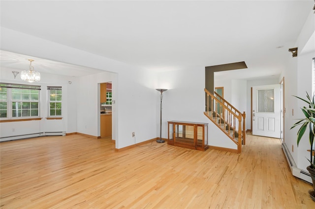 49 Tallmadge Trl, Miller Place, NY 11764 - unfurnished living room with wood finished floors, stairway, a chandelier, and a baseboard radiator