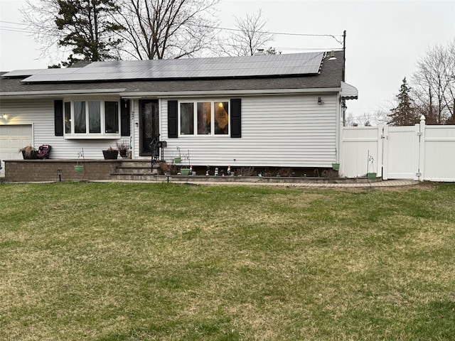27 Pandora Dr, Brentwood, NY 11717 - back of property with a gate, roof with shingles, a garage, and roof mounted solar panels