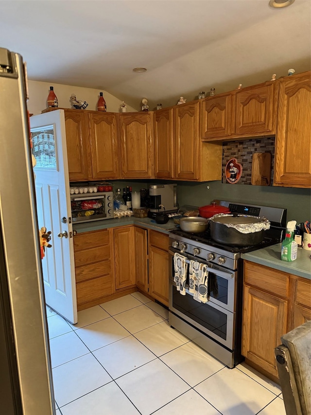 27 Pandora Dr, Brentwood, NY 11717 - kitchen with appliances with stainless steel finishes, vaulted ceiling, brown cabinets, and light tile patterned floors