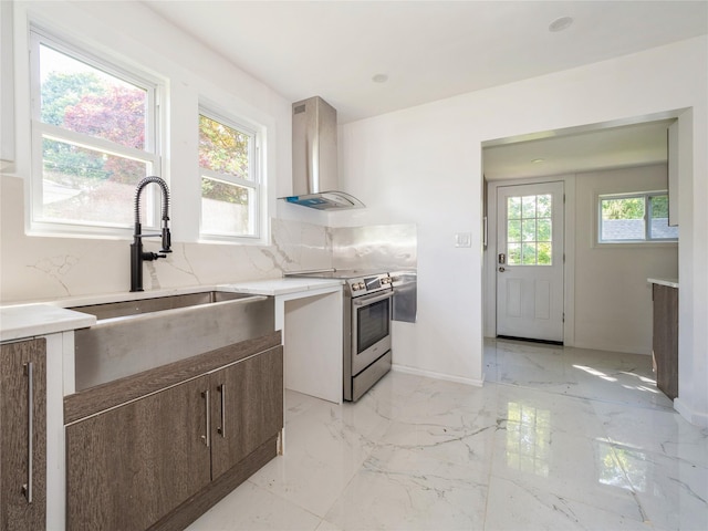 34 Woodland Ave, Poughkeepsie, NY 12603 - kitchen featuring wall chimney range hood, stainless steel range with electric cooktop, a sink, backsplash, and baseboards