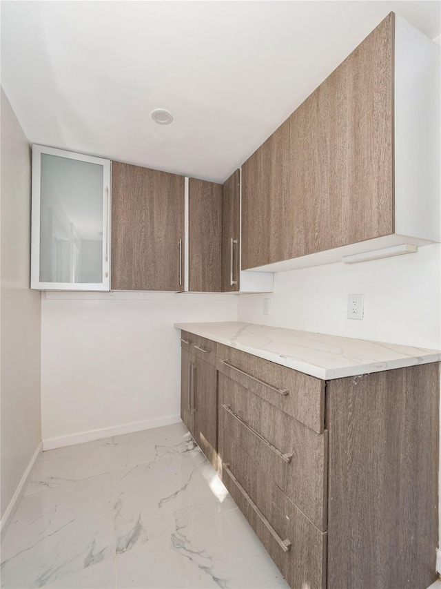 34 Woodland Ave, Poughkeepsie, NY 12603 - kitchen featuring baseboards, light marble finish floors, modern cabinets, and light stone countertops