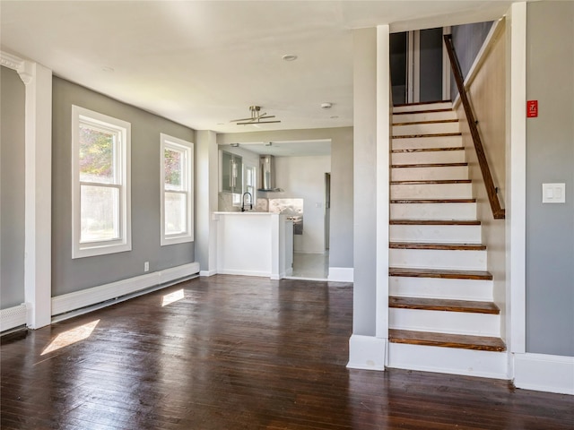 34 Woodland Ave, Poughkeepsie, NY 12603 - unfurnished living room with stairs, dark wood finished floors, a baseboard heating unit, a sink, and baseboards