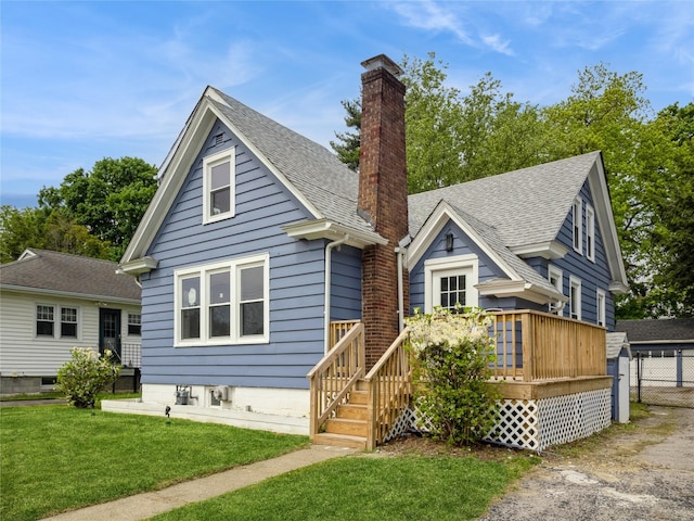 34 Woodland Ave, Poughkeepsie, NY 12603 - bungalow-style home with a chimney, a front lawn, a wooden deck, roof with shingles, and a detached garage