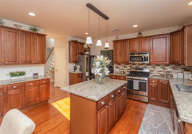 38 Panorama Dr, New Windsor, NY 12553 - kitchen with appliances with stainless steel finishes, light wood finished floors, light stone countertops, a kitchen island, and recessed lighting
