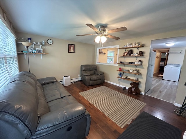 50 Tangier Dr, Sound Beach, NY 11789 - living room featuring wood finished floors, a ceiling fan, washer / dryer, baseboards, and a baseboard radiator