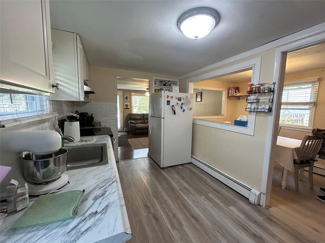 50 Tangier Dr, Sound Beach, NY 11789 - kitchen with freestanding refrigerator, baseboard heating, light countertops, and wood finished floors