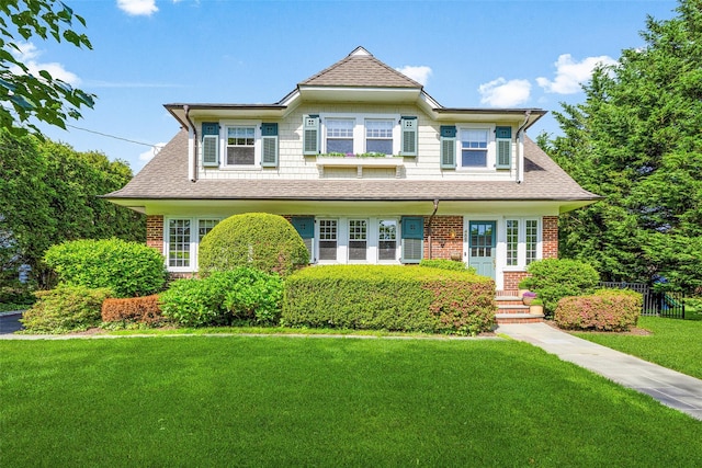 489 Manor Ln, Pelham, NY 10803 - view of front of house with a front yard, a shingled roof, and brick siding
