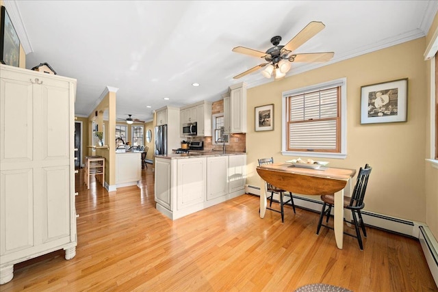16 Gibbs Rd, Amity Harbor, NY 11701 - kitchen with ceiling fan, appliances with stainless steel finishes, a peninsula, crown molding, and light wood-type flooring
