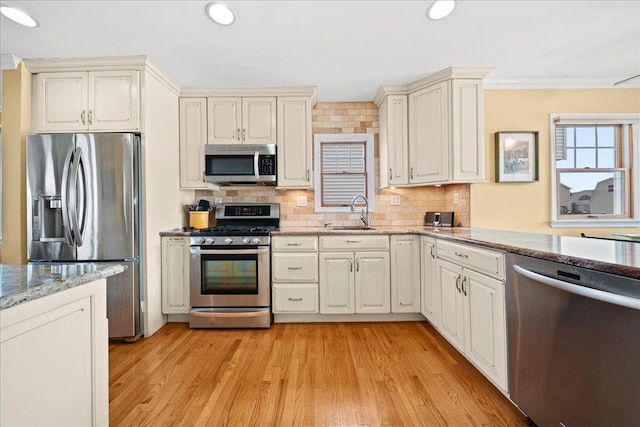 16 Gibbs Rd, Amity Harbor, NY 11701 - kitchen with appliances with stainless steel finishes, a sink, light wood finished floors, backsplash, and recessed lighting