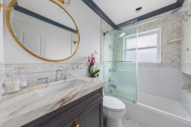 1696 Coral Rd, East Meadow, NY 11554 - full bathroom featuring tile walls, vanity, toilet, shower / bath combination with glass door, and wainscoting