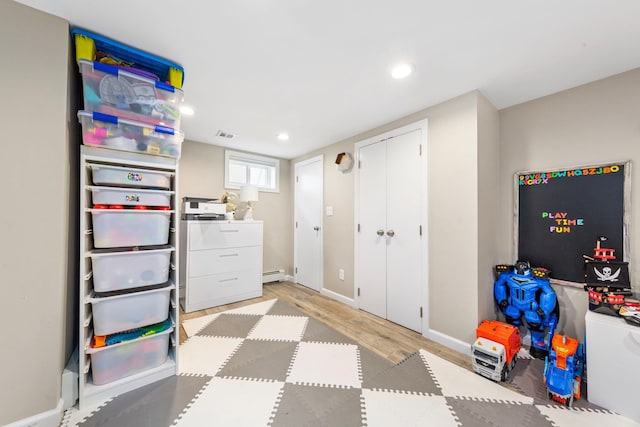 1696 Coral Rd, East Meadow, NY 11554 - rec room with light wood-style flooring, recessed lighting, baseboards, and a baseboard radiator