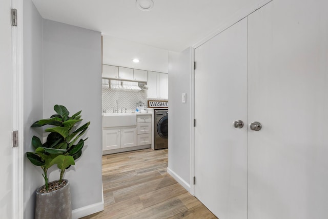 1696 Coral Rd, East Meadow, NY 11554 - corridor with washer / clothes dryer, light wood-style flooring, a sink, and recessed lighting