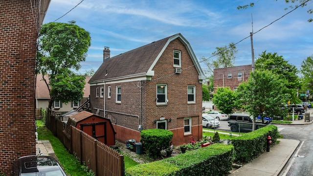 230 Pennyfield Ave, Bronx, NY 10465 - view of property exterior featuring brick siding, a chimney, and roof with shingles
