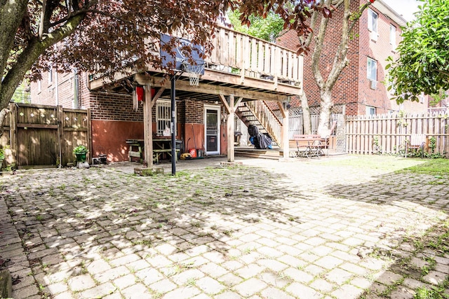 230 Pennyfield Ave, Bronx, NY 10465 - back of property with brick siding, stairs, a fenced backyard, and a wooden deck