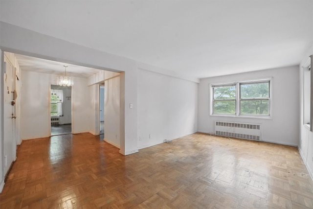 682 Tuckahoe Rd Unit 1A, Yonkers, NY 10710 - empty room featuring radiator heating unit, a chandelier, and baseboards