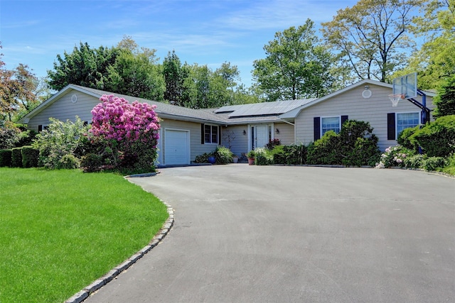12 Bridle Path Ln, Port Jefferson, NY 11777 - ranch-style house featuring an attached garage, driveway, solar panels, and a front lawn