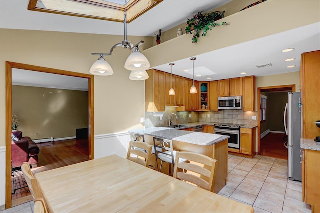 12 Bridle Path Ln, Port Jefferson, NY 11777 - kitchen with appliances with stainless steel finishes, a peninsula, glass insert cabinets, brown cabinets, and backsplash
