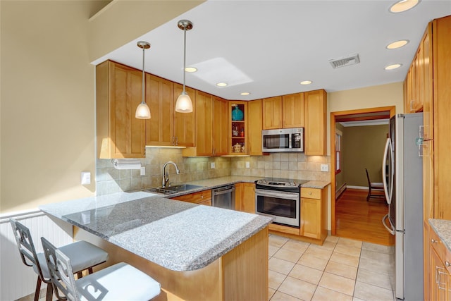 12 Bridle Path Ln, Port Jefferson, NY 11777 - kitchen featuring stainless steel appliances, a sink, a peninsula, light tile patterned flooring, and backsplash