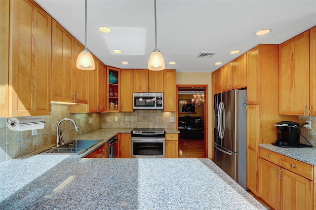 12 Bridle Path Ln, Port Jefferson, NY 11777 - kitchen featuring stainless steel appliances, a sink, hanging light fixtures, glass insert cabinets, and decorative backsplash