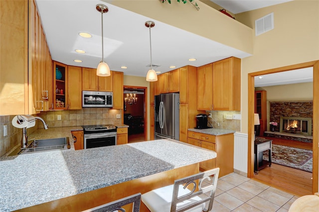 12 Bridle Path Ln, Port Jefferson, NY 11777 - kitchen with appliances with stainless steel finishes, a sink, decorative backsplash, light tile patterned flooring, and a peninsula