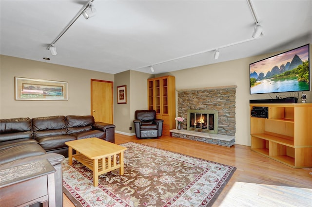 12 Bridle Path Ln, Port Jefferson, NY 11777 - living room featuring track lighting, wood finished floors, and a stone fireplace