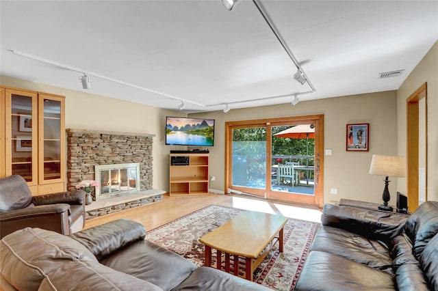 12 Bridle Path Ln, Port Jefferson, NY 11777 - living area featuring rail lighting, wood finished floors, and a fireplace