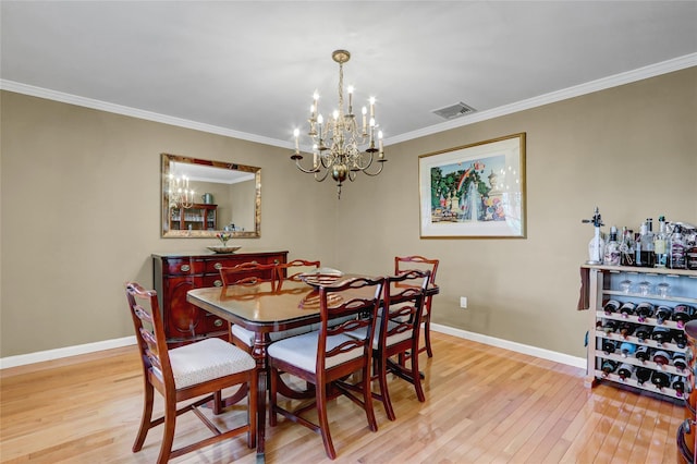 12 Bridle Path Ln, Port Jefferson, NY 11777 - dining space with a chandelier, light wood-style flooring, baseboards, and crown molding