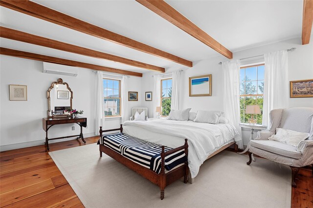 140AND144 Damascus Rd, East Quogue, NY 11942 - bedroom featuring an AC wall unit, multiple windows, beamed ceiling, and light wood-style flooring